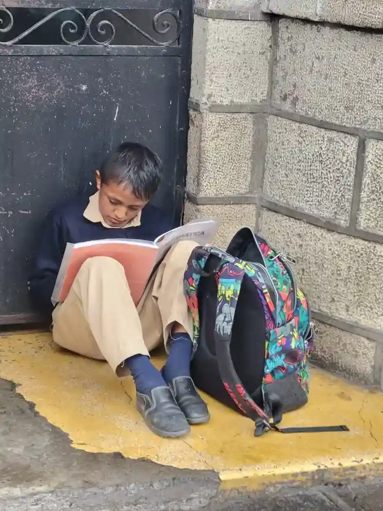 Niño busca salir adelante en medio de la lluvia en Riobamba 