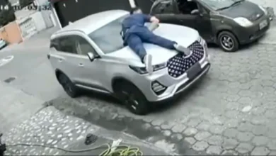 Se colgó del capó para evitar que le roben el carro